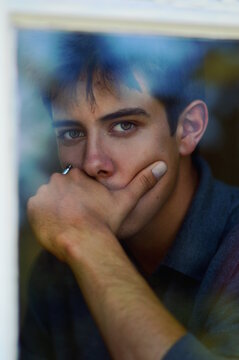 Portrait of young man with hand on mouth