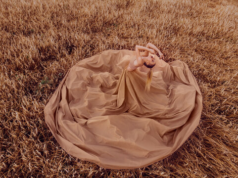 Top View Of Woman In Big Brown Dress Standing In Wheat Field