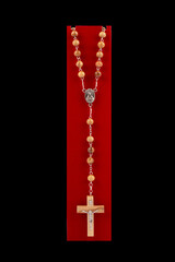 Traditional Christian holy religious wooden rosary isolated on black background.