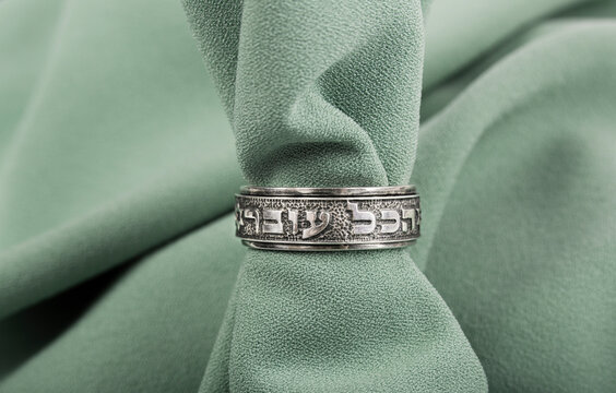 King Solomon's Kabbalah Ring This Too Shall Pass in Hebrew on green fabric background