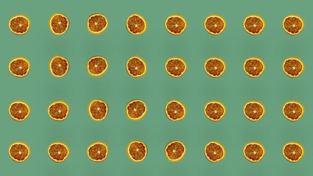 Colorful pattern of dried grapefruit slices on green background. Seamless pattern with dried grapefruit chips. Realistic animation. 4K video motion