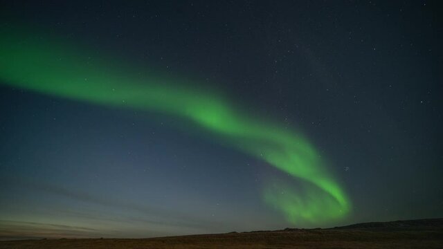 The beautiful show of the northern lights in the night sky above the fjord.