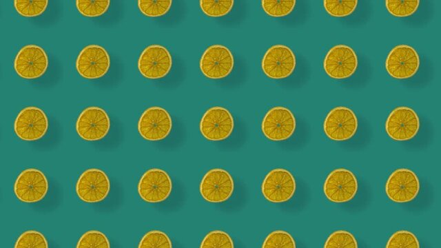 Colorful pattern of dried orange slices on green background with shadows. Seamless pattern with dried orange chips. Realistic animation. 4K video motion