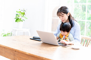 リモートで在宅ワークをする働きながら子供をなだめるママ1　コ ピースペースあり	