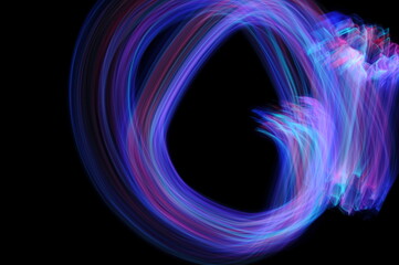 Light painting photography. Purple and blue abstract swirling texture against a black background.