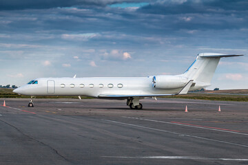 Modern white corporate business jet at the airport apron