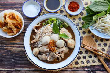 Thai style noodle soup served with vegetable flat lay on wood table - Famous street food, Thai boat noodle soup