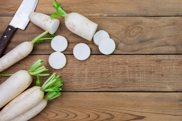 white radish and sliced ​​radishes placed on a simple wooden table with copy space - top view