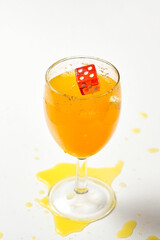 A dice falling into a glass of orange liquid caused a splash