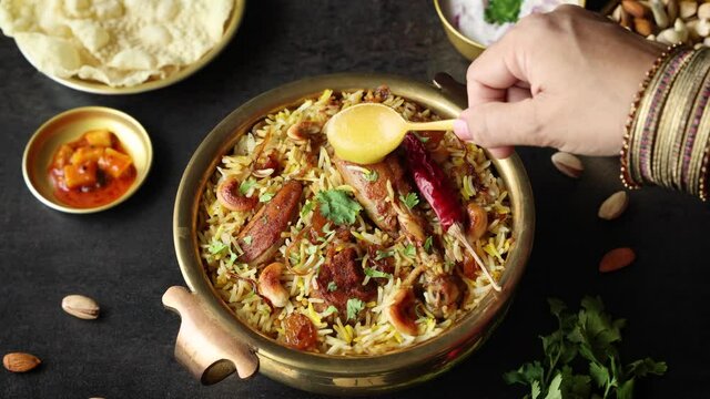 Chicken biryani Spicy Indian Malabar biryani Hyderabadi biryani woman hand serving ghee Dum Biriyani pulao 4K video footage Kerala India Sri Lanka basmati rice mixed rice dish meat curry Ramadan , Eid