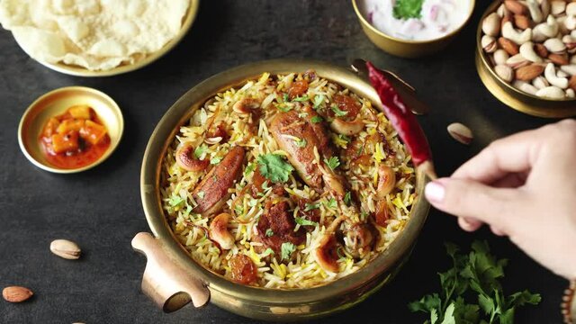 Chicken biryani Spicy Indian Malabar biryani Hyderabadi biryani woman hand serving Dum Biriyani pulao 4K video footage Kerala India Sri Lanka basmati rice mixed rice dish meat curry Ramadan , Eid