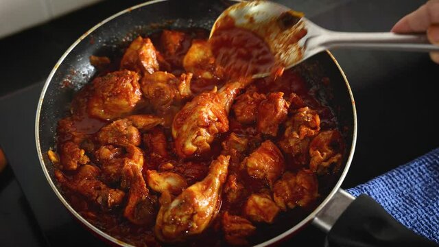 woman hand cooking red chicken roast curry Goan chicken vindaloo Butter chicken Murgh Makhani hot spicy dish 4K video footage Kerala Punjab India North Indian non-vegetarian cuisine Garam Masala tikka