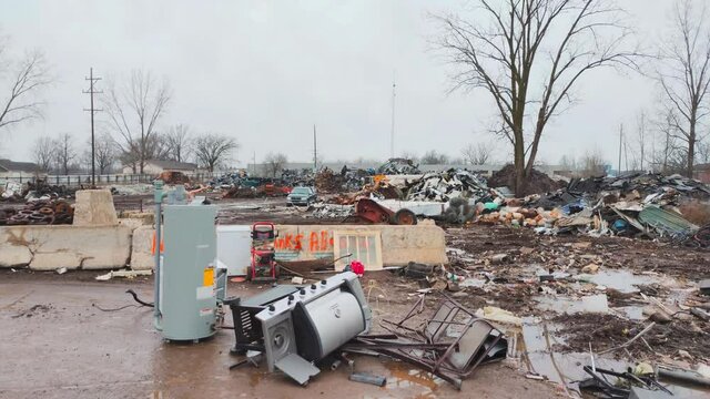 Dirty junk yard with excavator in background