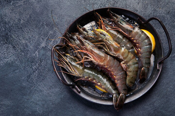 Raw shrimps on dark background.