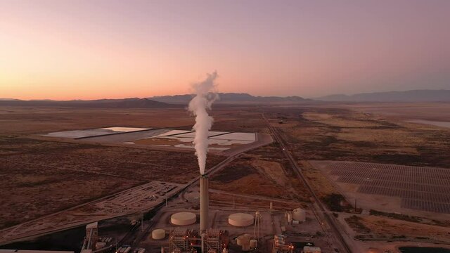 Power generation plant in Arizona at sunset. White steam coming from tower.
