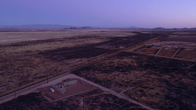 Arizona blue hour rural landscape over fields and electric supply station, drone ascending