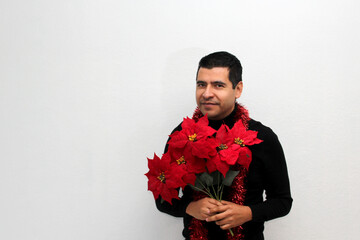 Latino adult man with Christmas hat shows Christmas decorations and decorations because he is ready to celebrate the holidays and the new year
