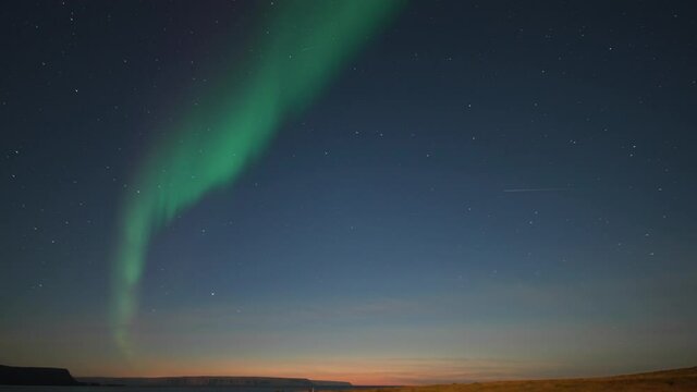 The beautiful show of the northern lights in the night sky above the desolate landscape.