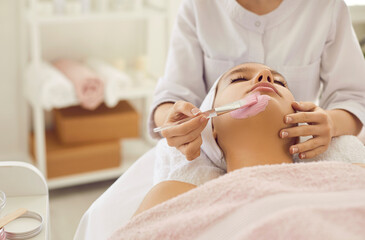 Woman getting facial treatment done by specialist in beauty salon or spa center. Beautiful lady...