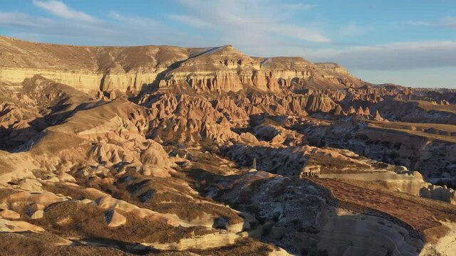 Aerial panoramic view of Cappadocia rose red valley near Göreme with rock formations in winter by sunset