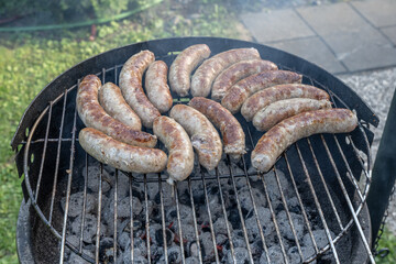 Barbecue grill bbq on coal charcoal grill with raw bratwurst sausages meat delicious summer meal