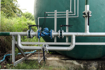 The joints and steel pipes transporting water up to a large water tank.