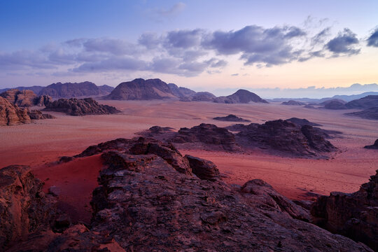 Wadi Rum desert, red sand with stone and rock. Evening orange sunset in nature. Travel Jordan, Arabia nature. Wadi Rum pik violet sunset, evening in the desert. Jordan nature landscape.