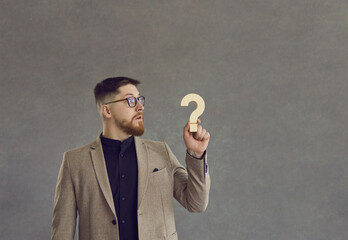 Side profile view of funny surprised puzzled confused man in suit and hipster glasses looking at...