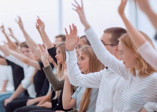 blurry image of young people asking questions.