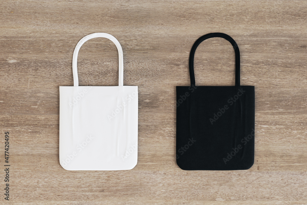 Aufkleber top view and close up of empty black and white shoppers on wooden surface background. mock up, adver