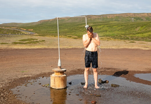 Man in swimsuit showering at the shower near Krafla