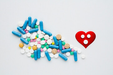 Many different tablets, red heart on white background. Medical flat lay . Valentine's Day.