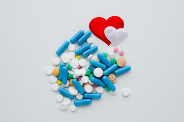 Many different tablets, red heart on white background. Medical flat lay . Valentine's Day.