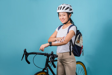 Beautiful asian women is cycling in the sun. She applied the cream and lotion and looked at the camera on a blue background.