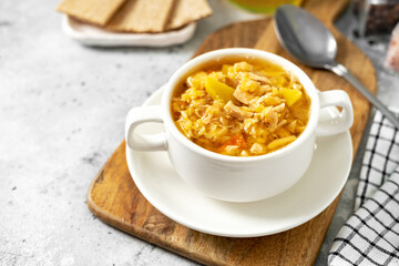 Pea soup with chicken in a white plate on a light cooking table	