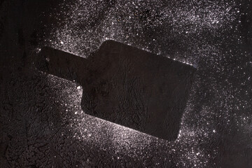 Cut board Silhouette  making with icing sugar on dark background .Concept for cooking dessert