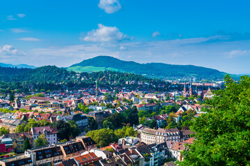 Germany, Freiburg im Breisgau aerial city panorama view surrounded by green mountains of the black forest nature landscape tourism region - obrazy, fototapety, plakaty