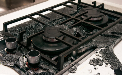 Debris from the explosion of a built-in gas hob in a glass ceramic hob in a kitchen
