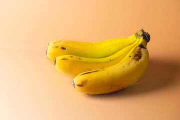 Banana bunch on beige  gradient background .Copy space