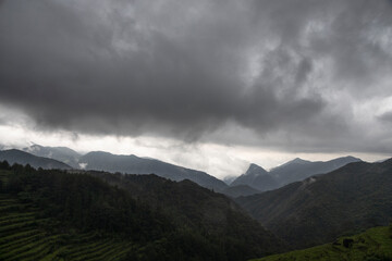 Obraz na płótnie Canvas High Mountains with dark clouds, bad weather