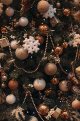 Festive Christmas tree decorated with beige gifts, snowflakes and golden Christmas balls. Magic cozy details, festive wallpaper