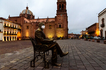 the sculpture of the man sitting at a bench at the Plaza de Armas in the center of Zacatecas, Mexico - obrazy, fototapety, plakaty