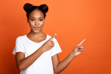 Photo of young attractive african lady indicate fingers empty space subscribe comment isolated over orange color background
