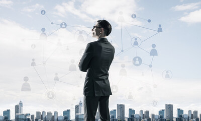 Concept of business success and control with confident boss against cityscape background