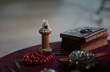 Photo of objects for fortune telling on the table. Books extinguished candle red obesity objects for fortune-telling.