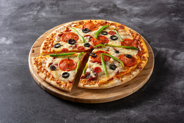 Traditional supreme pizza on black stone	
