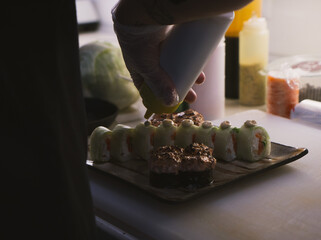 The photo of the finished Japanese food on the plate is beautifully laid out. Chef's hands close up.