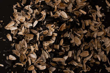 A mountain of husks from under the seeds lies on a black background