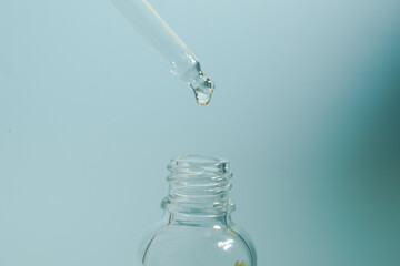 A bottle of care cosmetics, oil, serum, stands on the background under the light, the concept of advertising a product for women