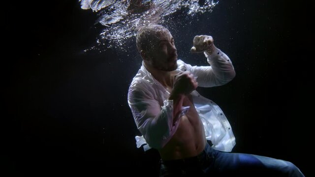 aggressive fighter underwater, amazing shot from down, male figure in dark depth
